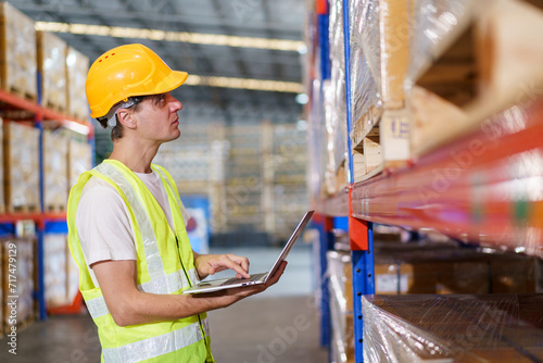 Caucasian male warehouse officer is currently conducting a stock inventory inside the warehouse. 