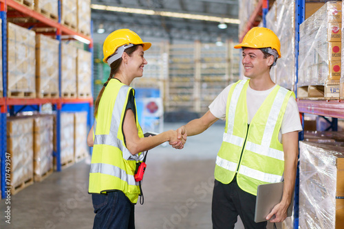 Tableau sur toile Caucasian male and female warehouse personnel engage in amicable conversation, culminating in a cordial handshake