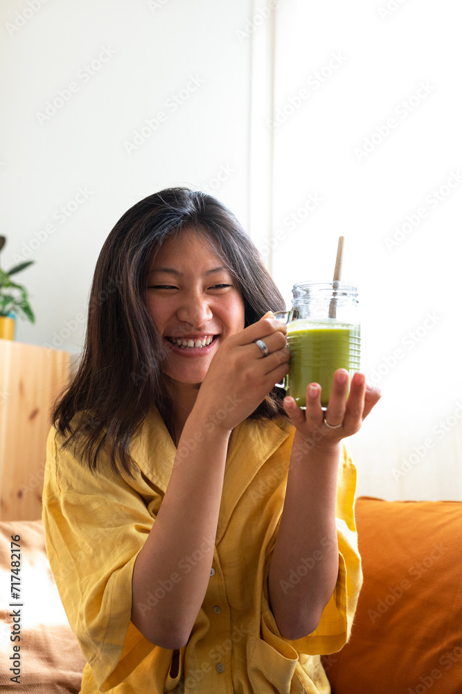 Happy teen asian girl showing healthy green juice. Vertical image. Happy teen asian girl showing healthy green juice. Vertical image.