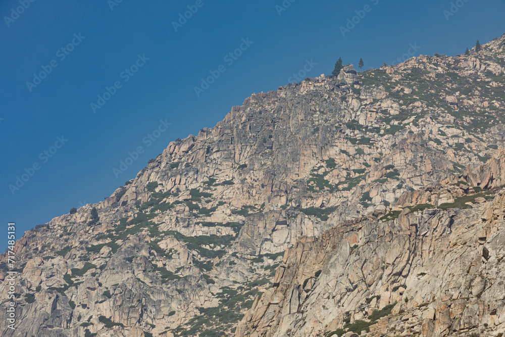 A very rocky mountain with a few trees and green patches in California against a blue sky on a Sunny Summer day. Nr.1 A very rocky mountain with a few trees and green patches in California against a blue sky on a Sunny Summer day. Nr.1