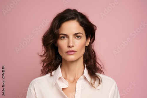 Portrait of a beautiful young woman in white shirt on pink background