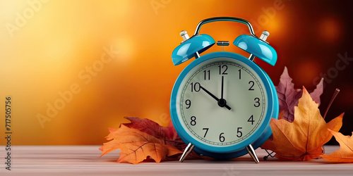 Daylight Saving Time. Alarm clock and orange color leaves on wooden table. Autumn time. Fall time change.copy space photo