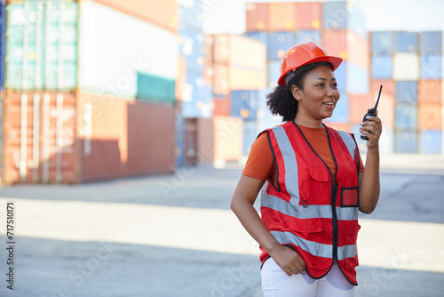 African factory worker or engineer holding wireless radio in containers warehouse storage
