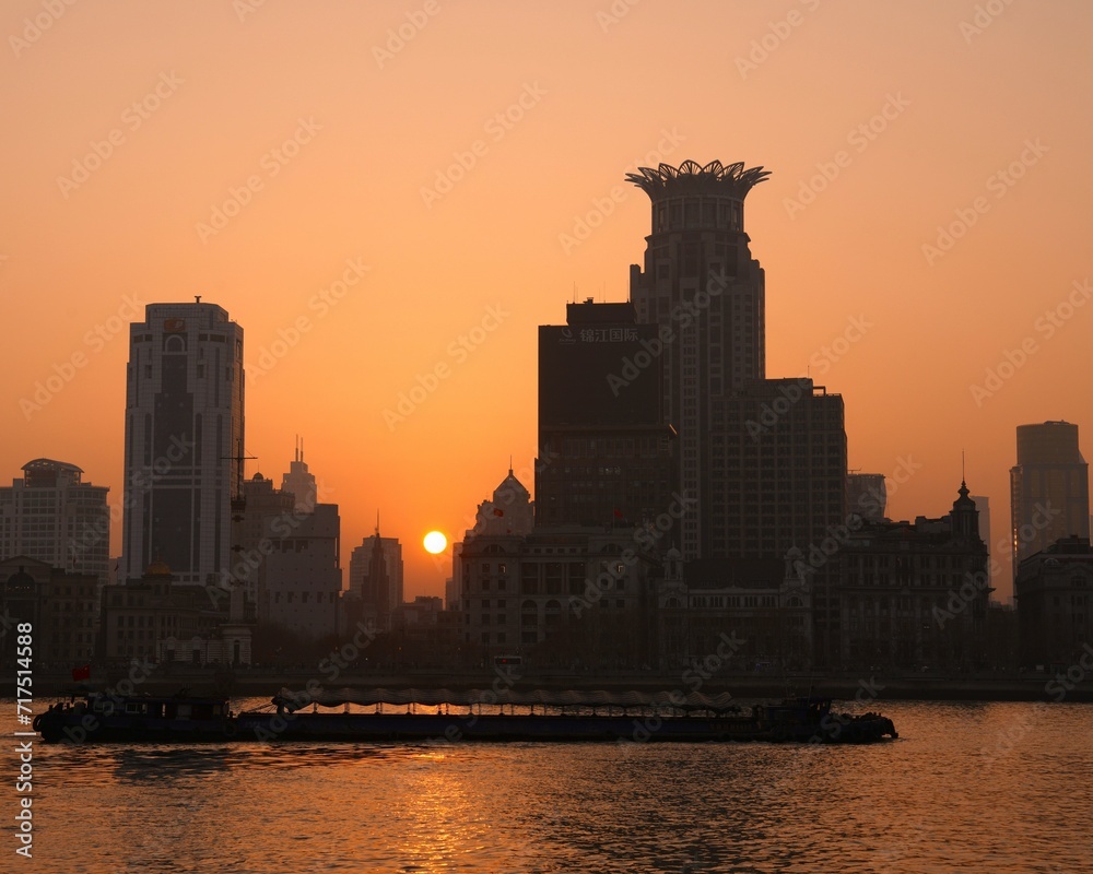 夕焼けに染まる黄浦江と摩天楼