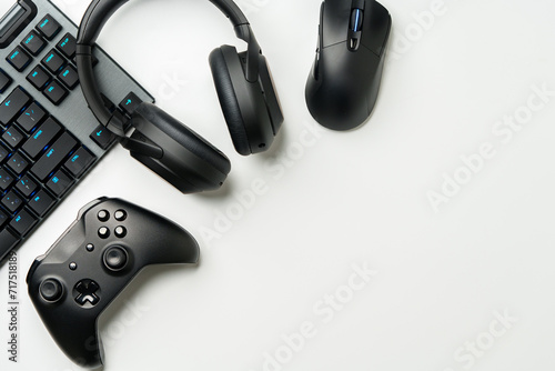 Top view of gamer table with computer keyboard, joystick and headphones