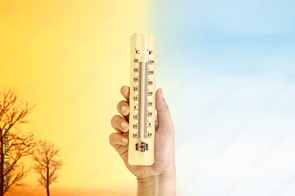 Human hand holding thermometer with a high heat temperature with a different sky Human hand holding thermometer with a high heat temperature with a different sky