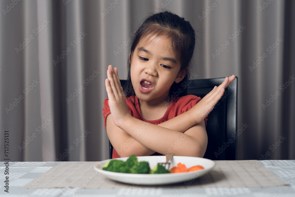 Little cute kid girl refusing to eat healthy vegetables. Children do not like to eat vegetables. Little cute kid girl refusing to eat healthy vegetables. Children do not like to eat vegetables.