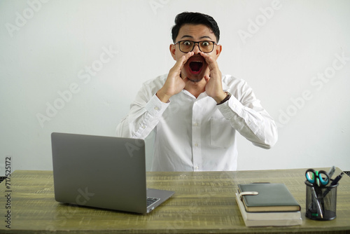 young asian businessman in a workplace shouting and announcing something, wear white shirt with glasses isolated