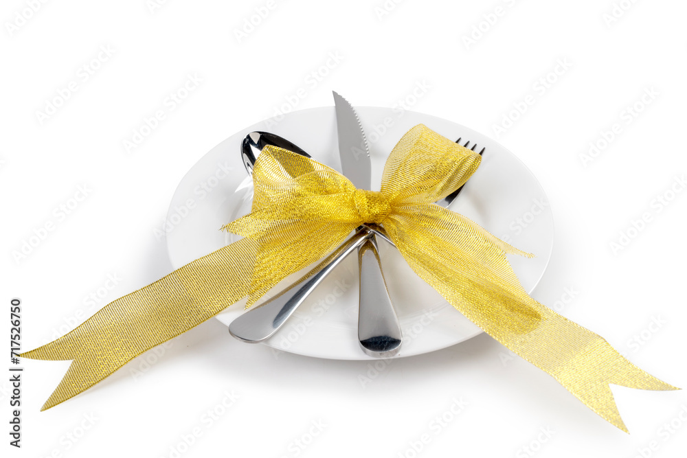 Fototapeta premium White plate with silverware of fork, knife, and spoon tied up on ribbon