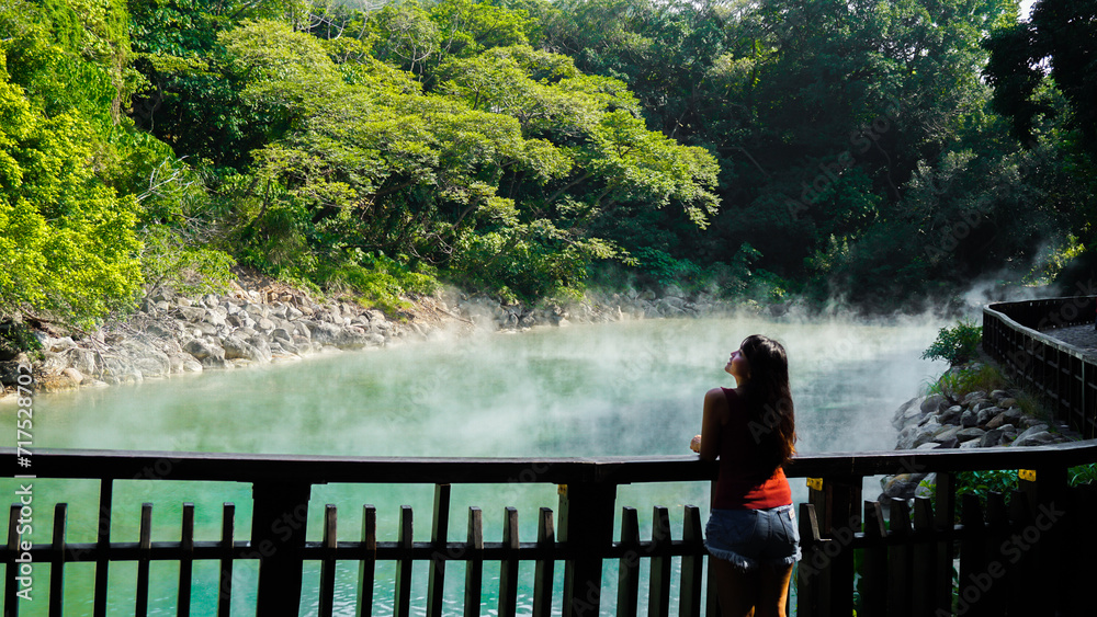 Obraz premium Hot spring water at Beitou Thermal Valley or Geothermal Valley, Taiwan. Woman traveler looking at Hot spring pond at Xinbeitou thermal valley in Taiwan.