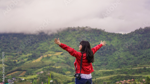 Women travel in mountains alone. Winter weather  calm scene. Backpacker walking outdoors  back view over landscape with sporty girl  green grass  forest  hills  sky  travel.