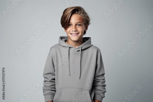 A portrait of a cute little boy in a hoodie on a gray background photo