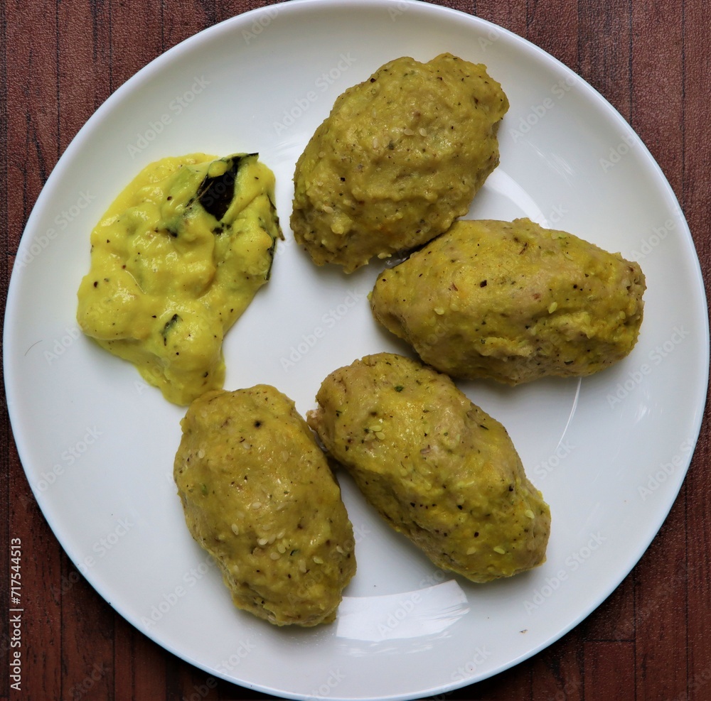 Nuchinunde recipe or steamed lentil dumplings or dal dumplings or nucchina unde, served along with vegetables in buttermilk gravy, popular breakfast or snacks recipe from Karnataka, India Nuchinunde recipe or steamed lentil dumplings or dal dumplings or nucchina unde, served along with vegetables in buttermilk gravy, popular breakfast or snacks recipe from Karnataka, India