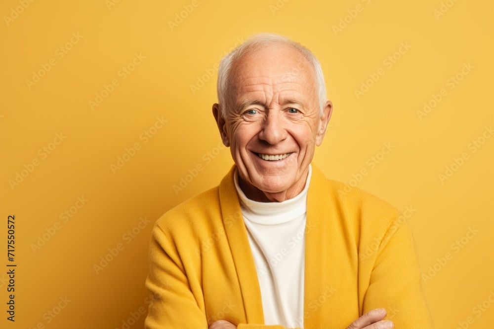 Portrait of a happy senior man in yellow sweater on yellow background Portrait of a happy senior man in yellow sweater on yellow background
