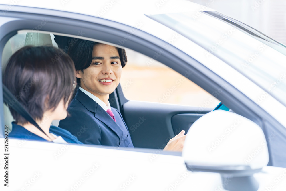女性に運転を指導する男性 自動車教習所 試乗車 カーディーラー 女性に運転を指導する男性 自動車教習所 試乗車 カーディーラー
