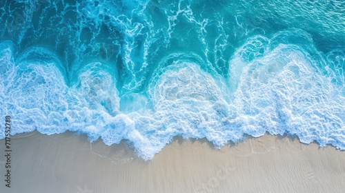 Soft waves of the blue ocean on a clean white sand beach. Top view.