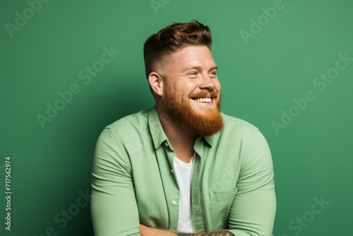 Portrait of a red-bearded man in a green shirt.