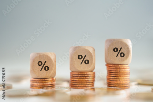 Business and financial growth, Interest rates increase, Inflation, Sale price, budget and tax rise concept. Wooden block with percentage sign on growing of stack of money coins.