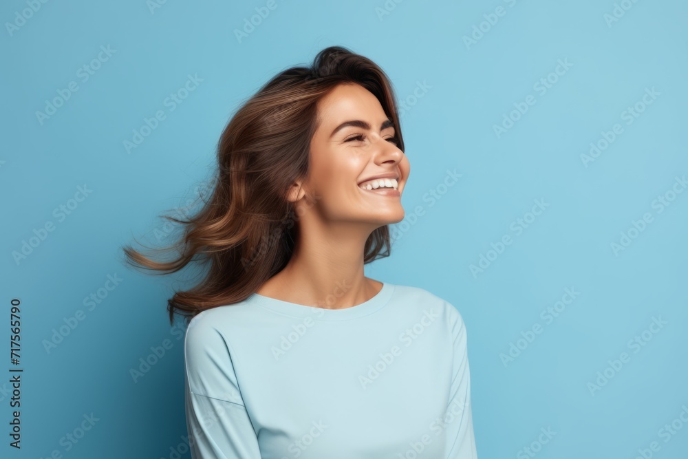 Beauty portrait of young happy smiling woman, isolated on blue background Beauty portrait of young happy smiling woman, isolated on blue background