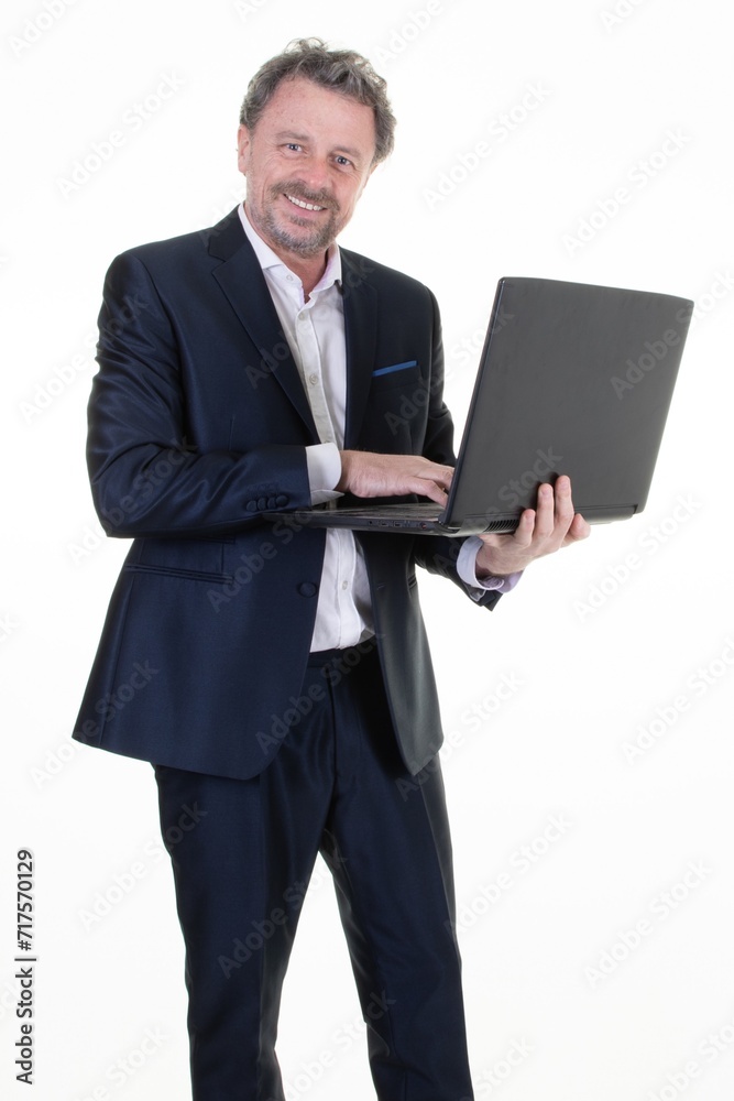 Portrait of smiling man professional manager dressed in suit holding laptop businessman working on wireless computer standing middle aged on white background Portrait of smiling man professional manager dressed in suit holding laptop businessman working on wireless computer standing middle aged on white background