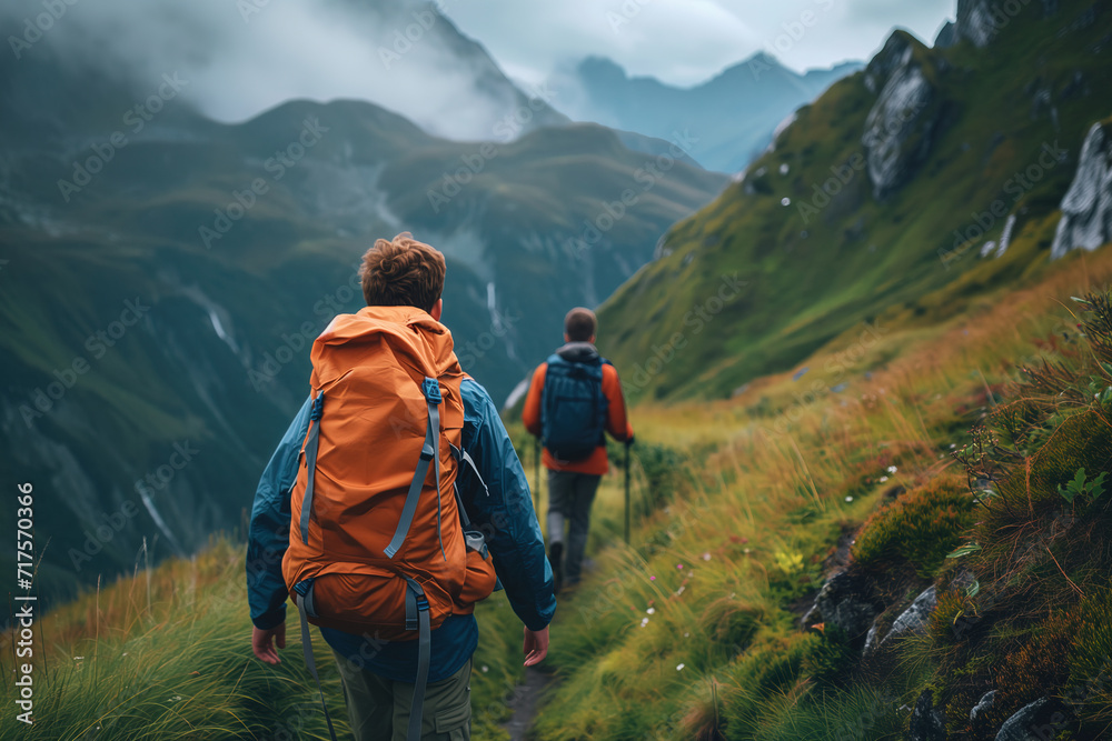 Two hikers on the trail in the moody mountains