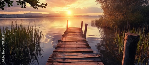 landscape of a lake at sunset and with a wooden jetty. Copy space image. Place for adding text or design #717572315