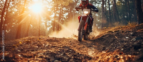 Motorcycle balance and motion blur with a man at a race on space in the forest for dirt biking Bike fitness and power with a sports person driving fast on an off road course for freedom or spee photo