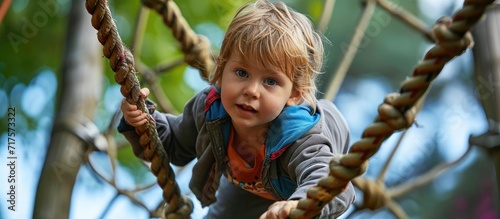 Little boy climbing on the rope at playground. Copy space image. Place for adding text or design