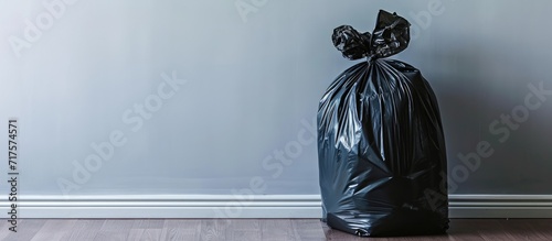 Hand removing black rubbish bag with debris from kitchen waste bin. Copy space image. Place for adding text or design photo