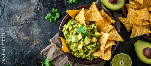 Guacamole avocado mash dip with tortilla chips and fresh avocados. Copy space image. Place for adding text or design photo