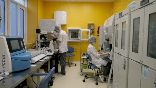 Doctors perform sample analysis at the modern medical test clinic. Medical specialists using testing equipment at the clinic. Medical professionals testing the embryos at the clinic. photo