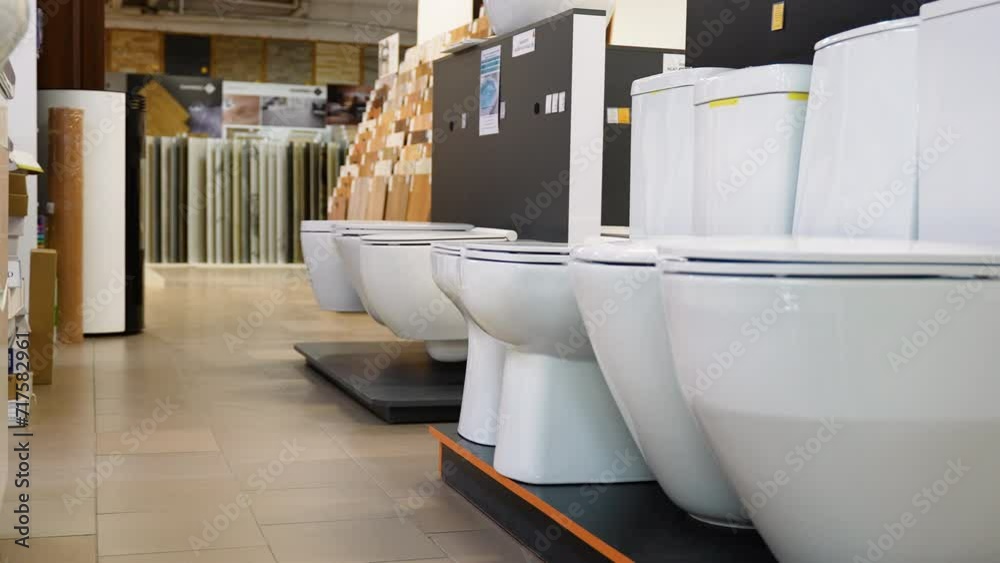 Ceramic toilet bowls of different types and color in a shop StockVideo