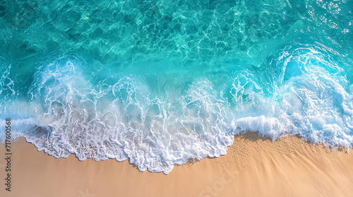 Aerial view of a white sand beach with crystal clear turquoise waters, waves, and shoreline