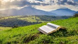 Bible Resting on a Grass Hill: The Bible laid open on a lush green grassy hill, surrounded by the serenity of nature and distant mountains.