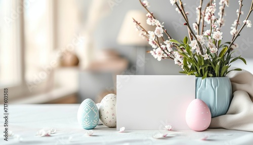 Mockup for a greeting card. Blank greeting card on a table with flowers. Colorful Easter eggs and spring flowers on easter festive background. Happy Easter! Empty greeting card, postcard or banner. photo