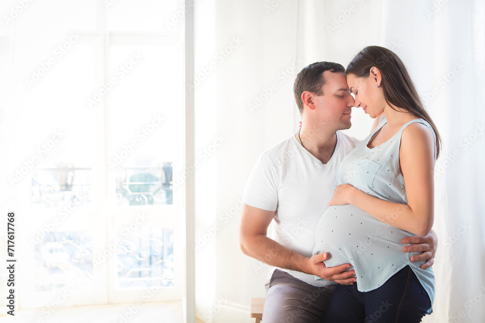 Pregnant woman and young man together indoors Pregnant woman and young man together indoors