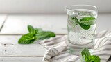 mint in glass, glass of soda water, mint and napkin on white wooden table. Space for text
