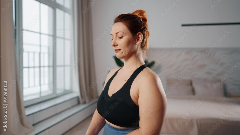 Woman training exercising at home. Middle aged female fitness newcomer doing body rotations exercises to keep herself in shape, to lose weight. Sport, healthy lifestyle, workout, wellness concept. Woman training exercising at home. Middle aged female fitness newcomer doing body rotations exercises to keep herself in shape, to lose weight. Sport, healthy lifestyle, workout, wellness concept.