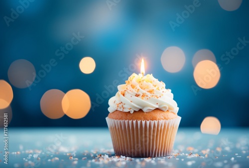 birthday cupcake with candles open up blue background with gold confetti