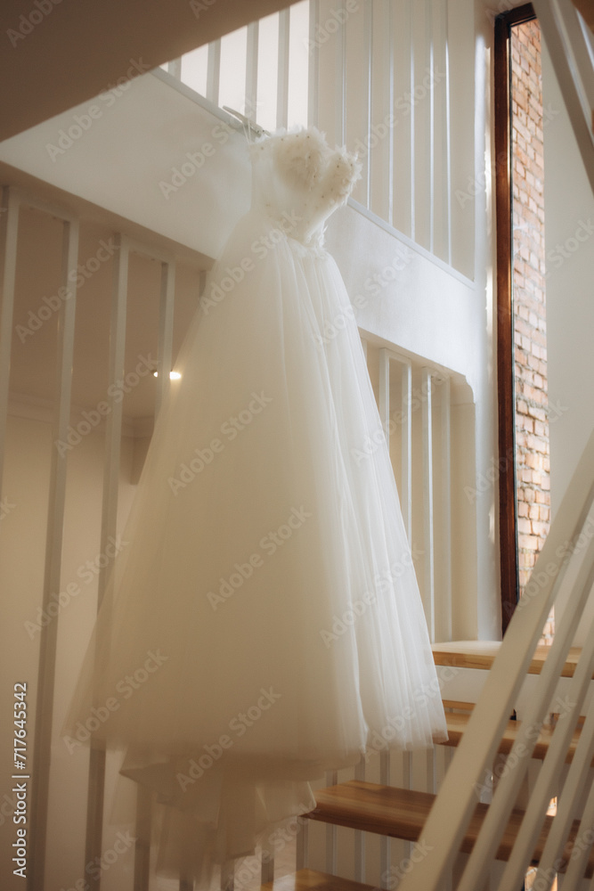 wedding dress hanging on luster at hotel room