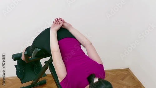 Wallpaper Mural Young woman exercising on a bench for back hyperextension, Video Clip 4K Torontodigital.ca