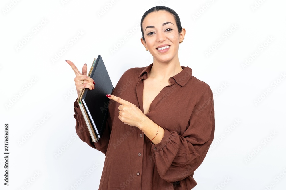 Beautiful young woman indicating finger empty space showing best low prices, looking at the camera Beautiful young woman indicating finger empty space showing best low prices, looking at the camera