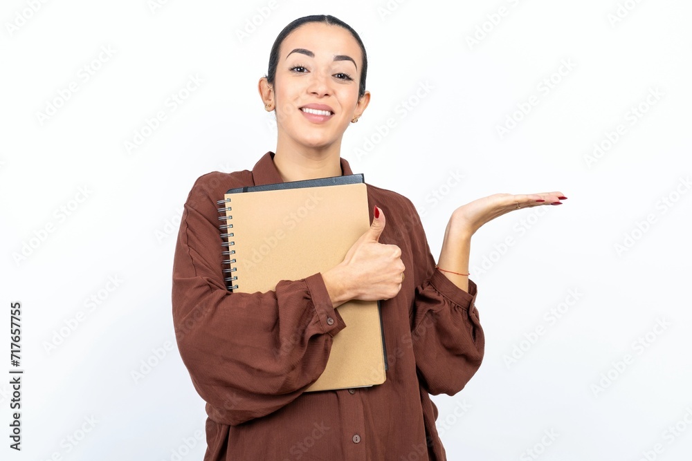 Young beautiful woman Showing palm hand and doing ok gesture with thumbs up, smiling happy and cheerful. Young beautiful woman Showing palm hand and doing ok gesture with thumbs up, smiling happy and cheerful.