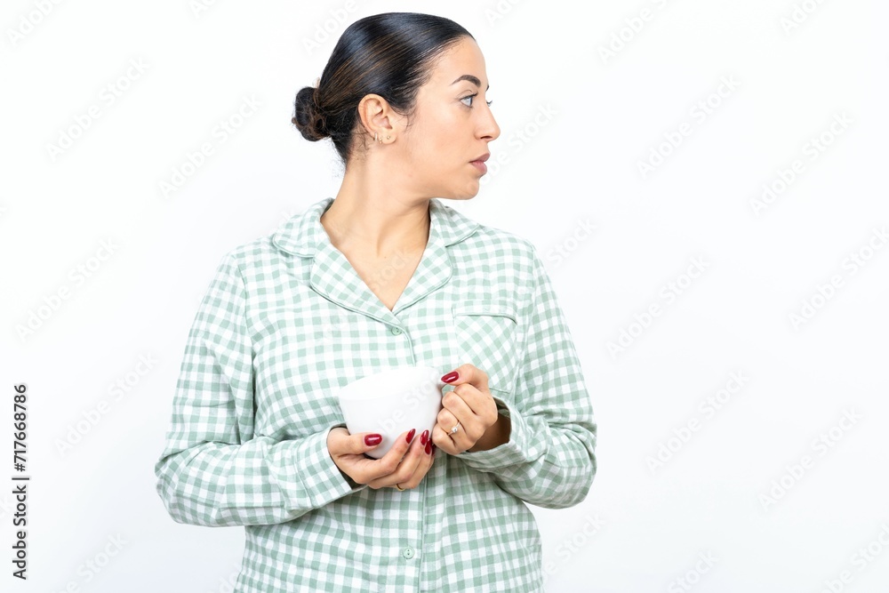 Close up side profile photo Beautiful young woman wearing green plaid pyjama not smiling attentive listen concentrated Close up side profile photo Beautiful young woman wearing green plaid pyjama not smiling attentive listen concentrated