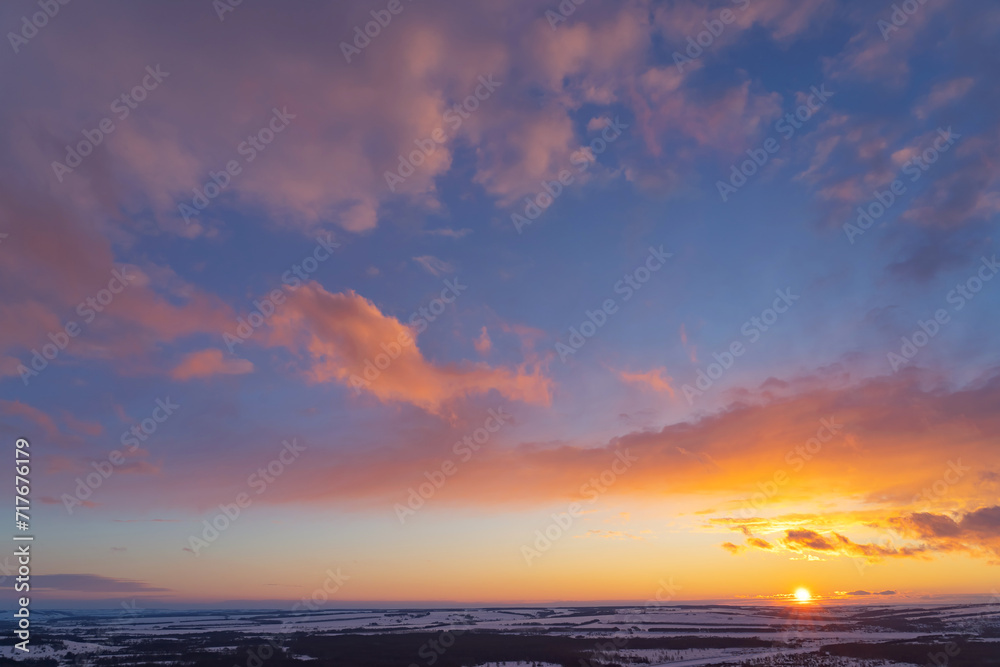 winter evening, sunset in yellow, orange and pink with clouds, background