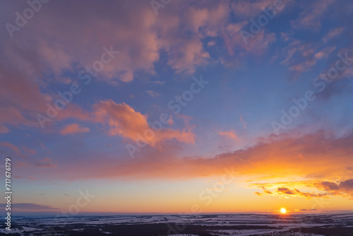 winter evening  sunset in yellow  orange and pink with clouds  background