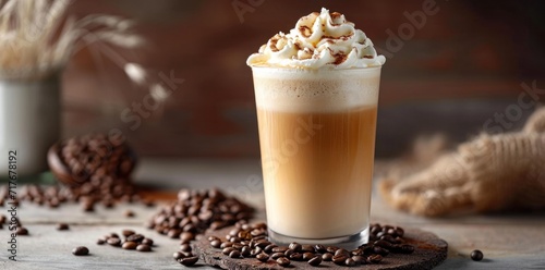a coffee drink with whipped cream on top with coffee beans in the background