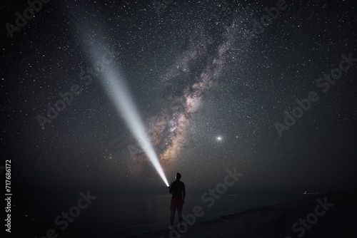 Under the vast starry sky lies an explorer with a beam of light; unveiling mysteries of the cosmic world from a silent shore.