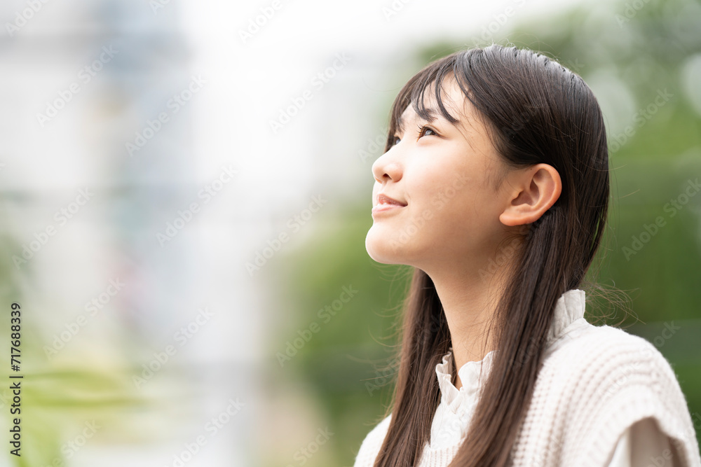 グリーンをバックに遠くを見ている女の子 グリーンをバックに遠くを見ている女の子