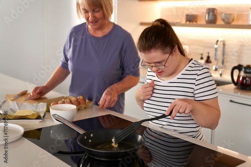Obraz na płótnie Down syndrome woman and her mother preparing breakfast together w salonie